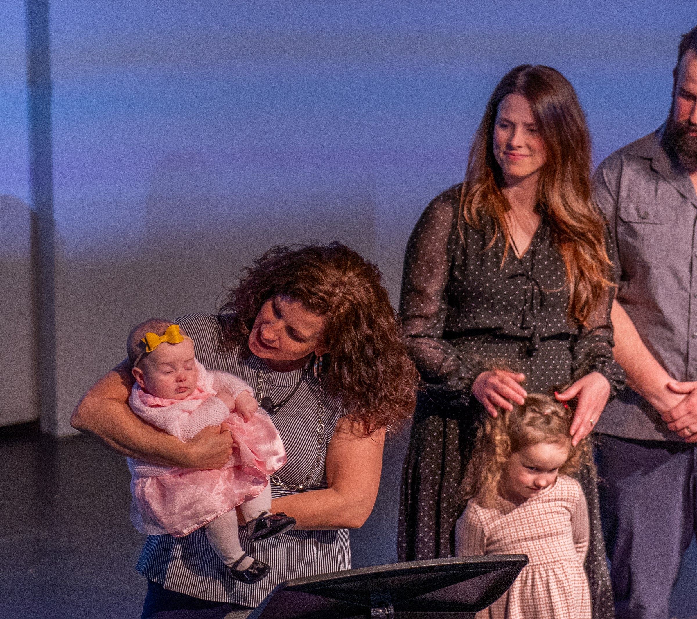A pastor blessing a child on stage during a Parent Child Dedication at Tidal Church