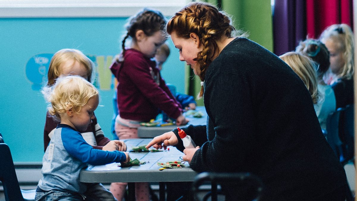 Volunteers helping toddlers with a craft in a Tidal Church childcare room