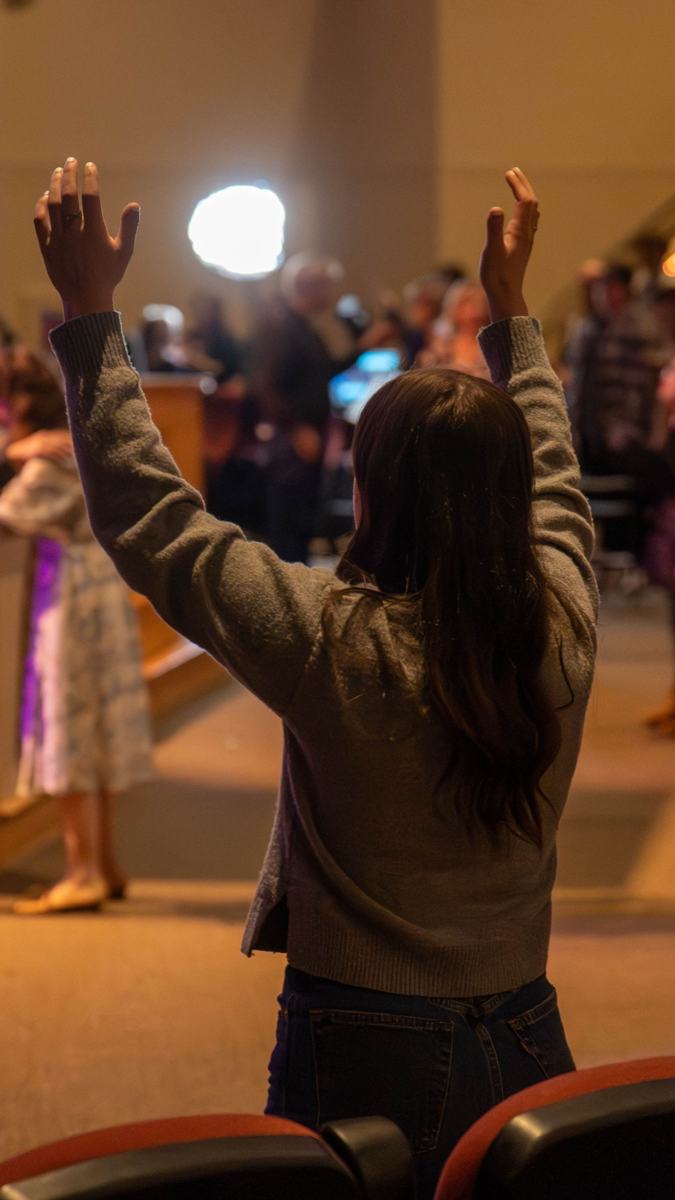 A woman with raised hands during worship