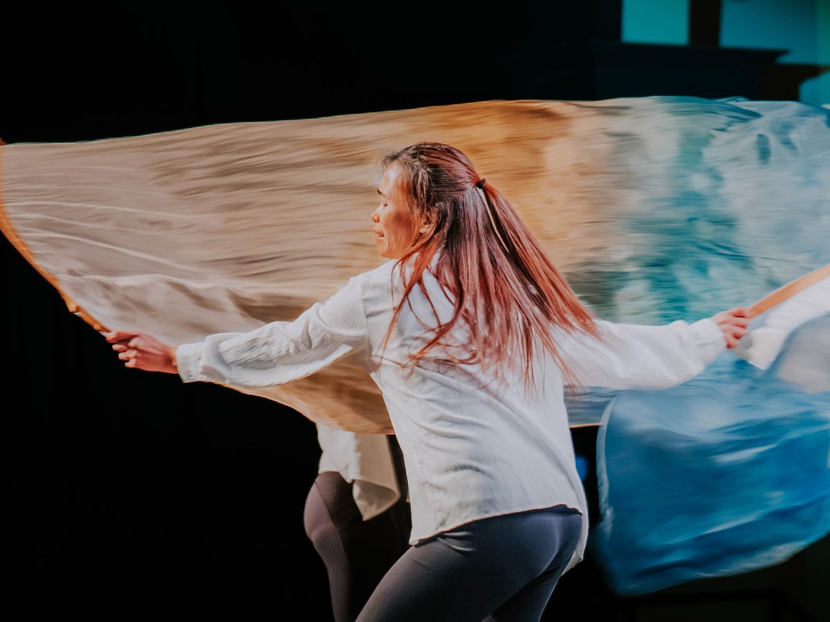 A dancer moving with flowing fabric during a worship service