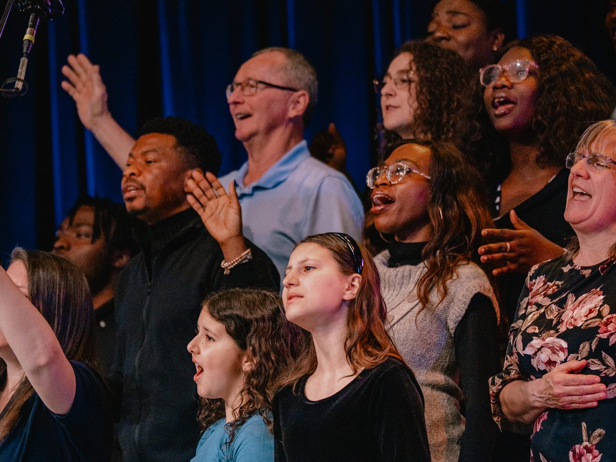 The Tidal choir singing together on stage