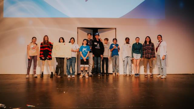 Tidal Youth students and leaders posing on stage together
